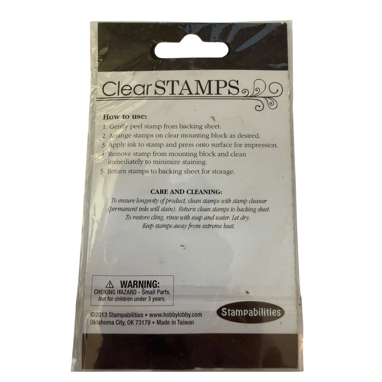 Clear STAMPS stamping block packaging by Stampabilities, showing the back of the clear plastic bag with printed instructions, a warning label, and the Stampabilities logo.