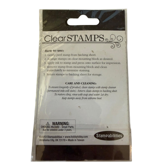 Clear STAMPS stamping block packaging by Stampabilities, showing the back of the clear plastic bag with printed instructions, a warning label, and the Stampabilities logo.