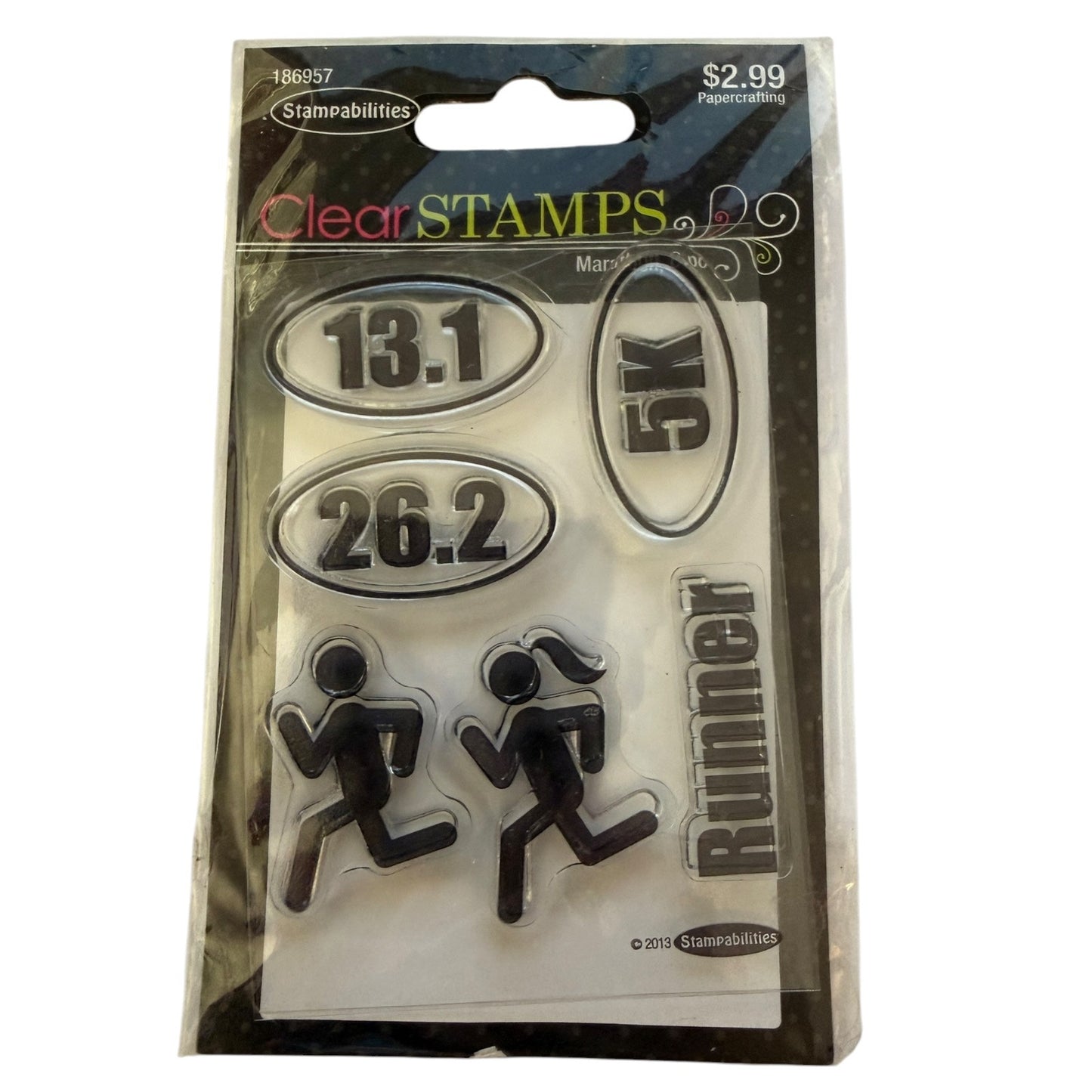 Stamabilities Clear STAMPS 5-pack of clear rubber stamps in a black plastic blister pack, featuring oval number stamps, running figures, and a vertical 'Runner' stamp.