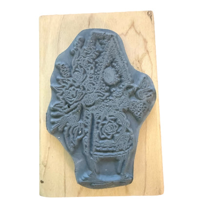 Decorative rubber stamp with intricate design on a wooden block