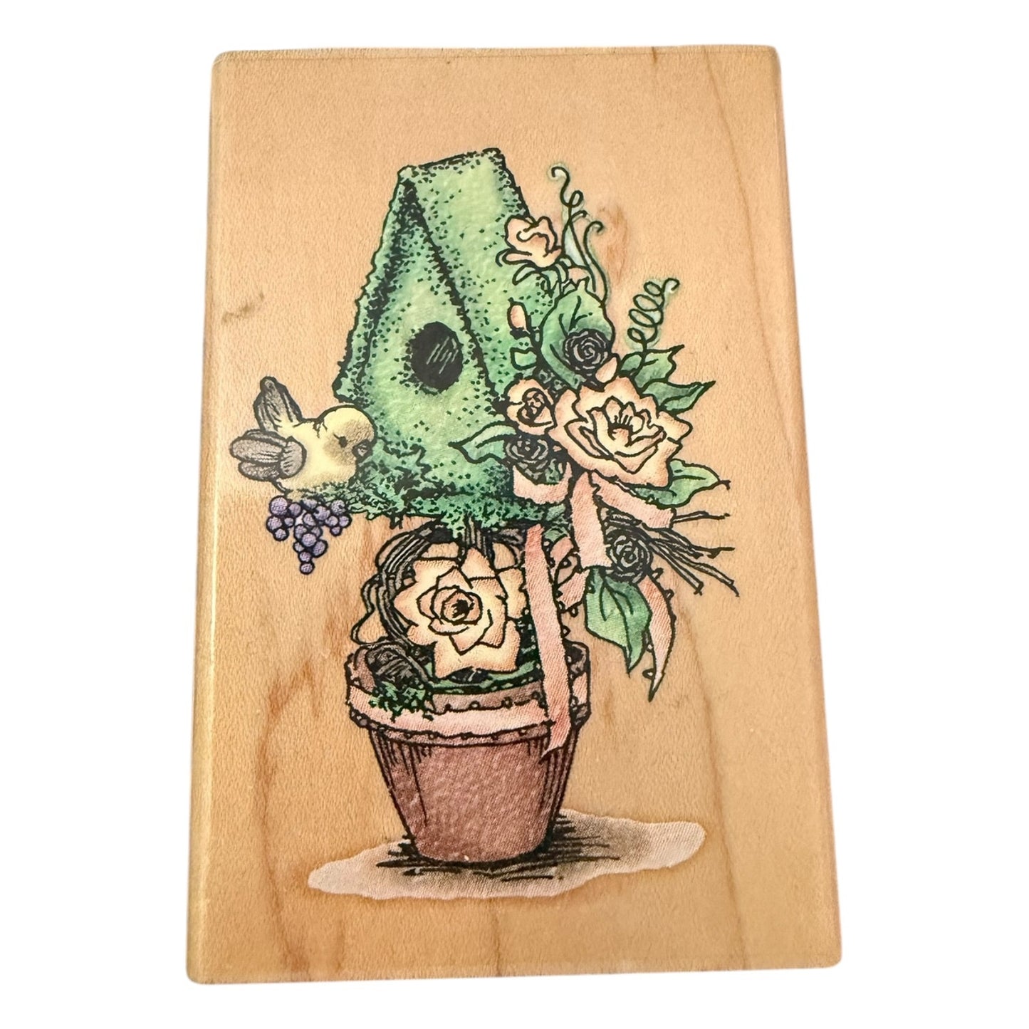 Wooden block with a colorful illustration of a plant with flowers & bird on a wooden background