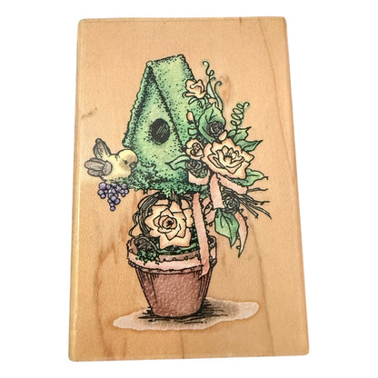 Wooden block with a colorful illustration of a plant with flowers & bird on a wooden background