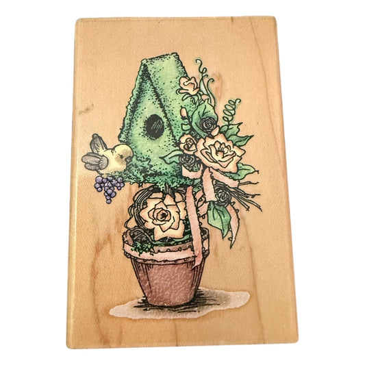 Wooden block with a colorful illustration of a plant with flowers & bird on a wooden background