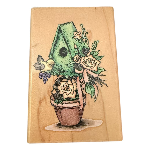 Wooden block with a colorful illustration of a plant with flowers & bird on a wooden background