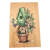 Wooden block with a colorful illustration of a plant with flowers & bird on a wooden background