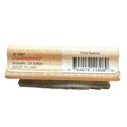 A wooden stamp block with a white  label showing a barcode, model number H105 Beehive, photographed on a white background.