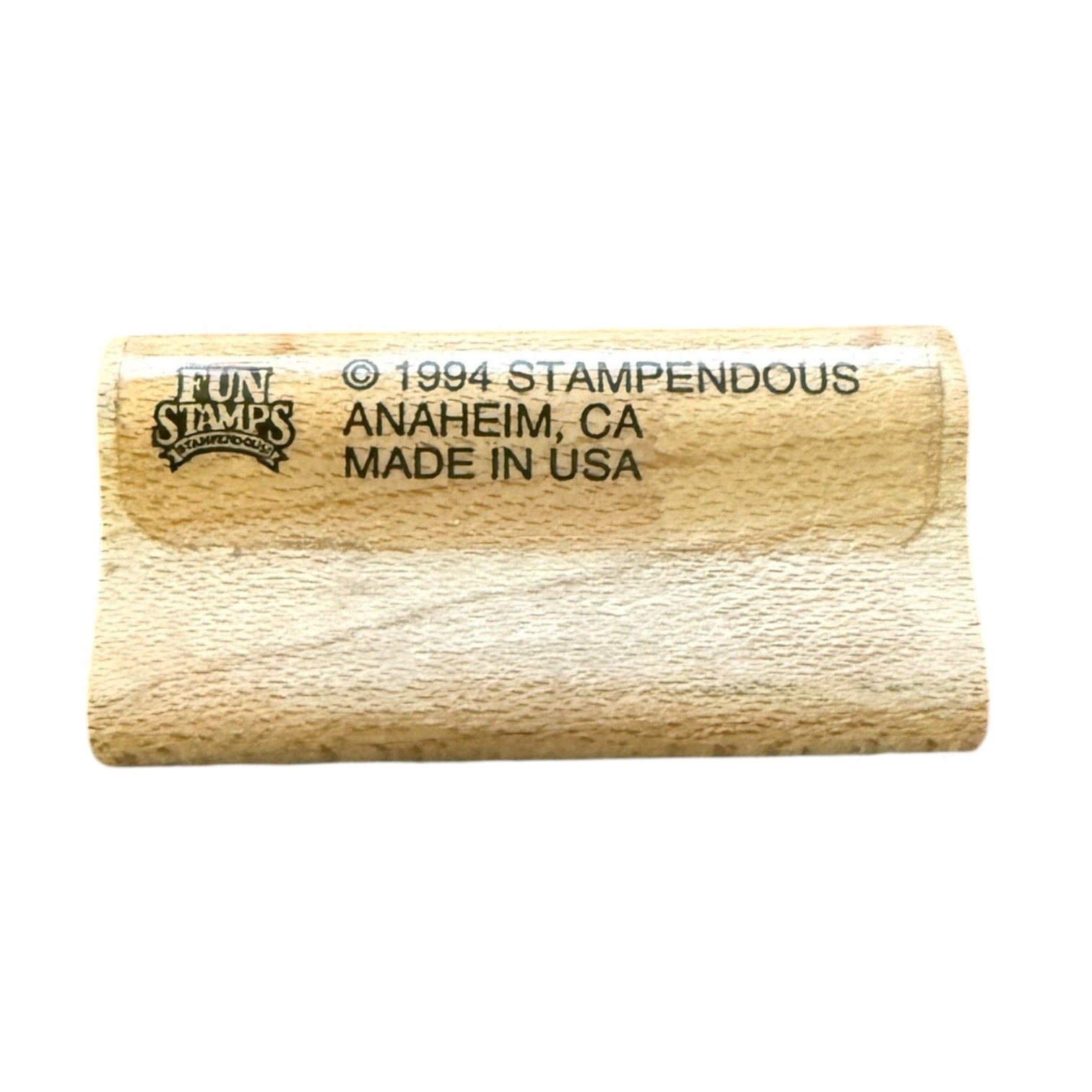 A close-up of a wooden stamp blank with black printed text reading 'FUN STAMPS' and '© 1994 STAMPENDOUS ANAHEIM, CA MADE IN USA' on a plain white background.