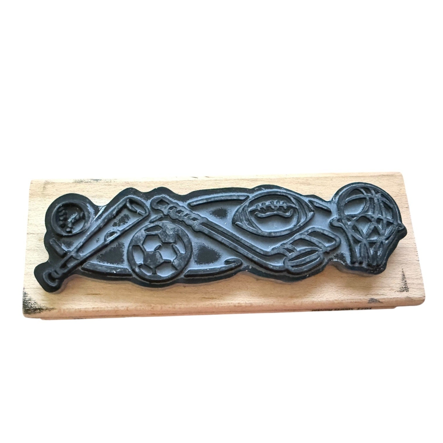 Decorative gray stamp with sports design on a wooden board.