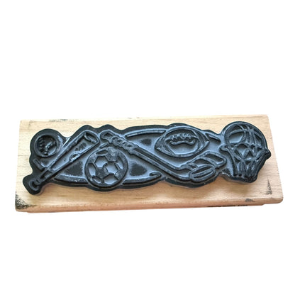 Decorative gray stamp with sports design on a wooden board.