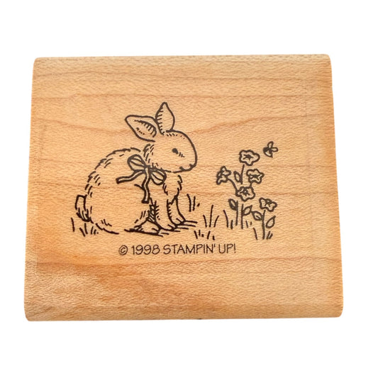 A square wooden stamp block featuring a black illustration of a rabbit wearing a bow and small flowers, with the text '© 1998 STAMPIN' UP!' printed on the front, shown on a plain white background.