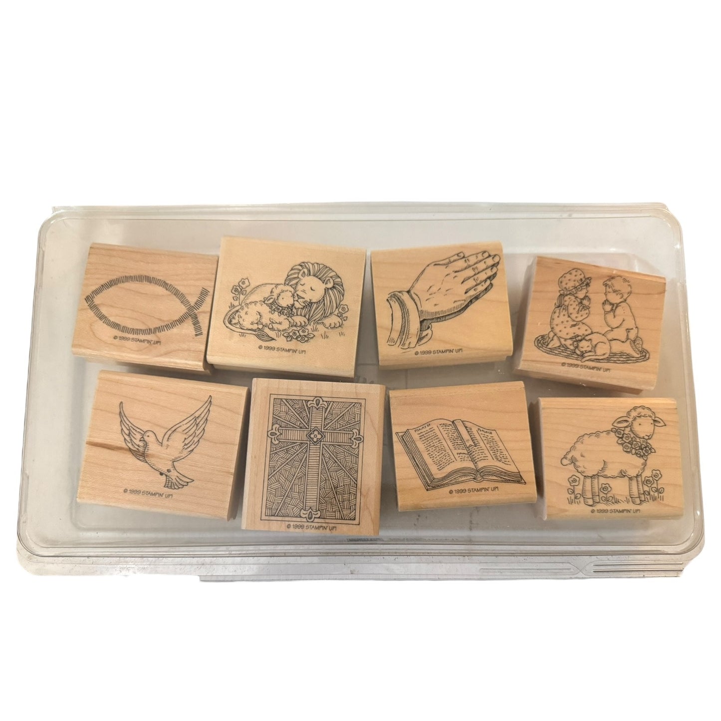 Set of wooden stamps with various designs in a clear plastic case on a white background