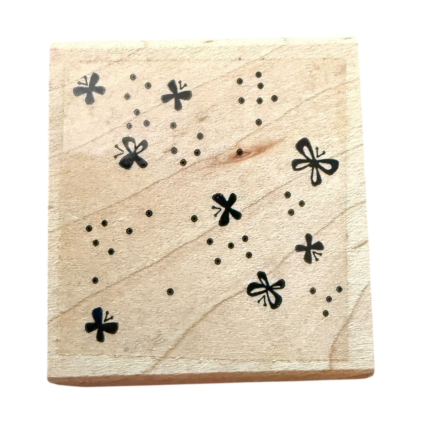 Wood block with dots and butterfly patterns on a white background