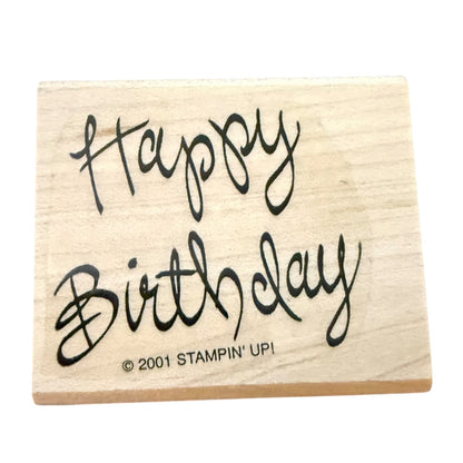 A square wooden rubber stamp block with 'Happy Birthday' written in black cursive script and '© 2001 STAMPIN' UP!' printed below, shown on a plain white background.