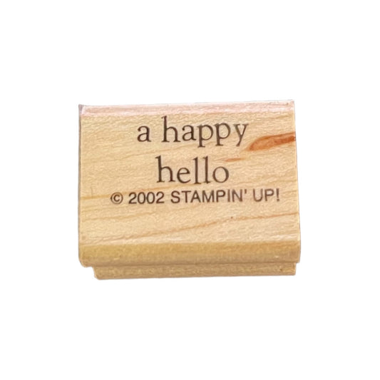 Wooden stamp with 'a happy hello' text on a white background
