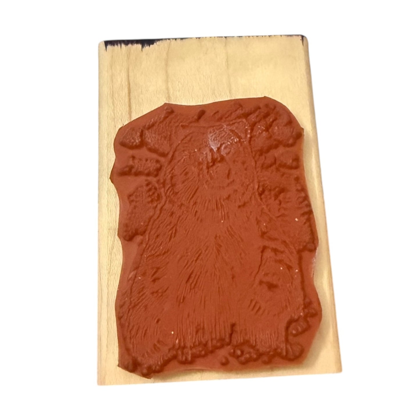 Red rubber stamp with bear design on a wooden block