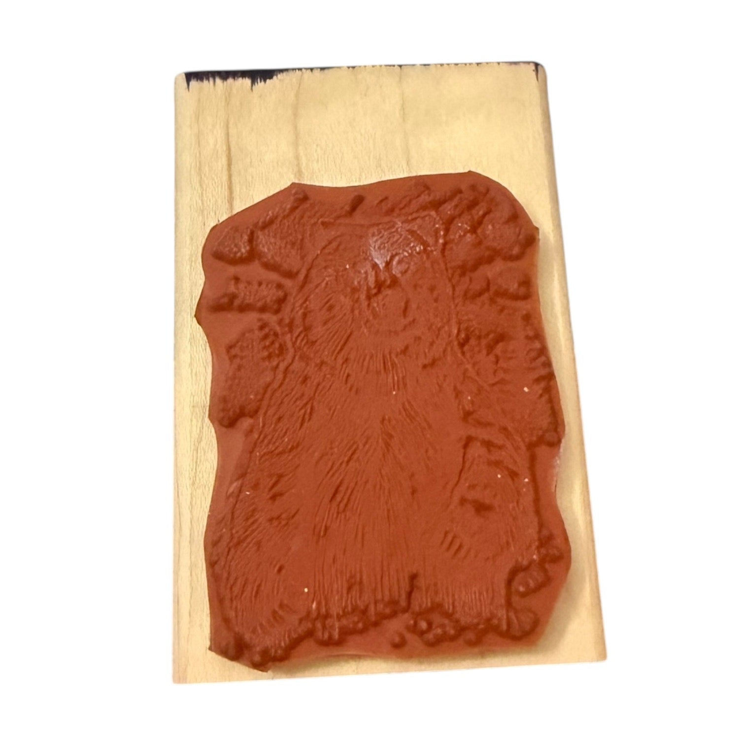 Red rubber stamp with bear design on a wooden block