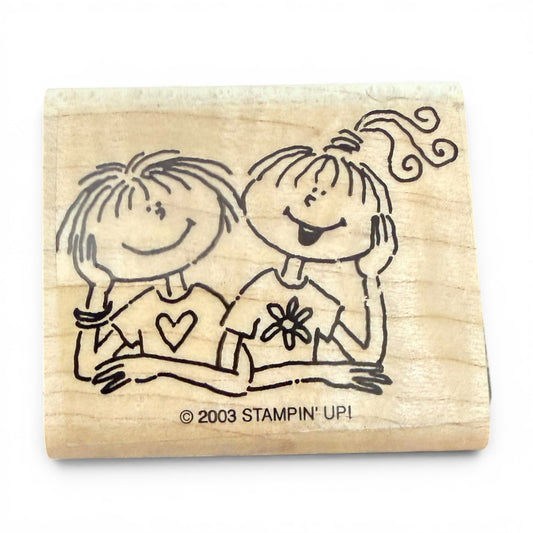 Wooden stamp with illustrations of two children on a white background, featuring the 'Stampin' Up!' brand.