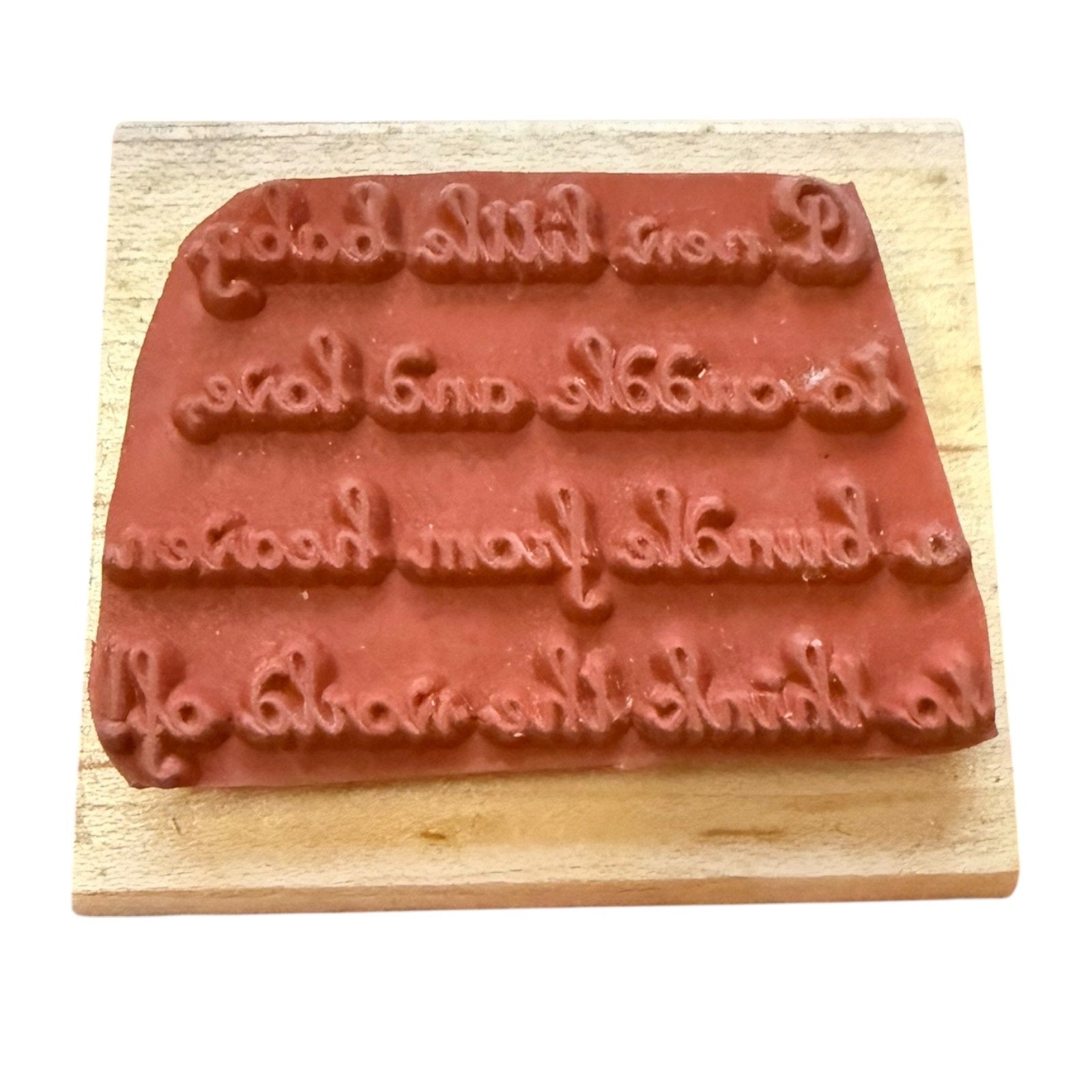 Wooden stamp with embossed text on a white background