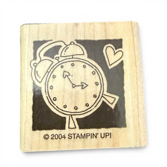 Wooden stamp with clock design and '2004 Stampin' Up!' text on a white background