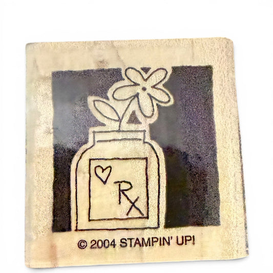 Rubber stamp with a design of a bottle and flowers, featuring the 'Stampin' Up!' logo.