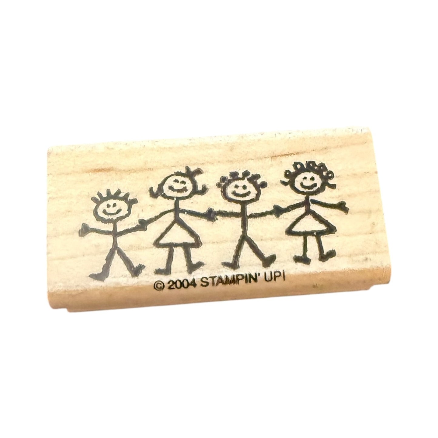 Wooden stamp with stick figure family design and '2004 Stampin' Up!' branding on a white background.