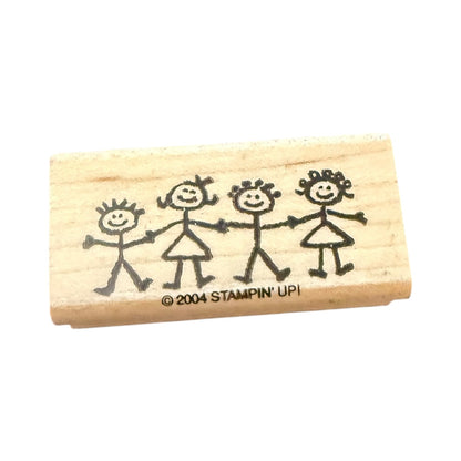 Wooden stamp with stick figure family design and '2004 Stampin' Up!' branding on a white background.