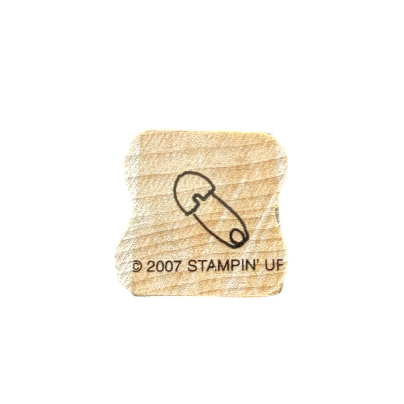 Wooden stamp with a safety pin and '2007 Stampin' Up!' text on a white background