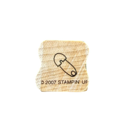 Wooden stamp with a safety pin and '2007 Stampin' Up!' text on a white background