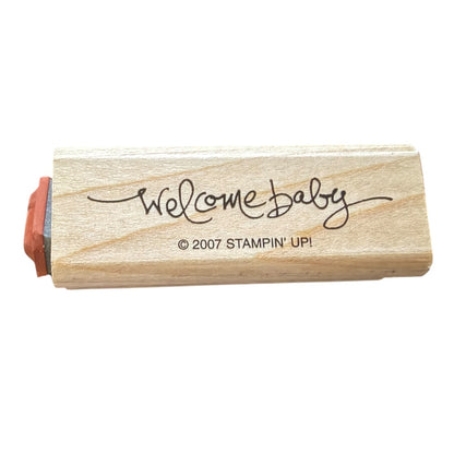 Wooden stamp with 'Welcome Baby' text and Stampin' Up! branding on a white background