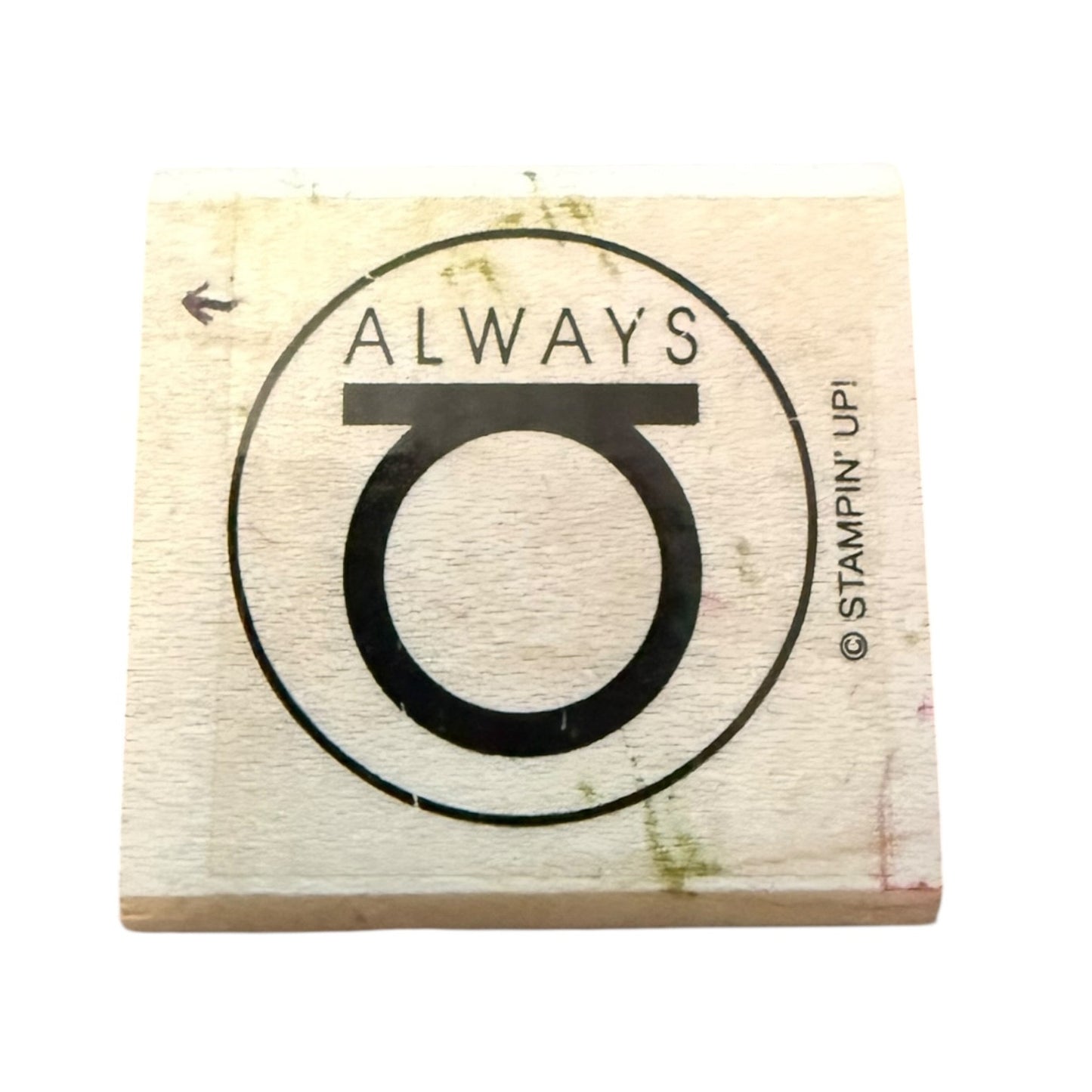 A square wooden rubber stamp block featuring a black printed design with the word 'ALWAYS' above a large stylized letter O, shown on a plain white background. Stampin' Upi branding is visible on the right side of the design.