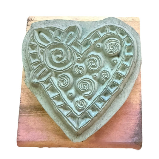 Heart-shaped stamp with decorative patterns on a wooden block