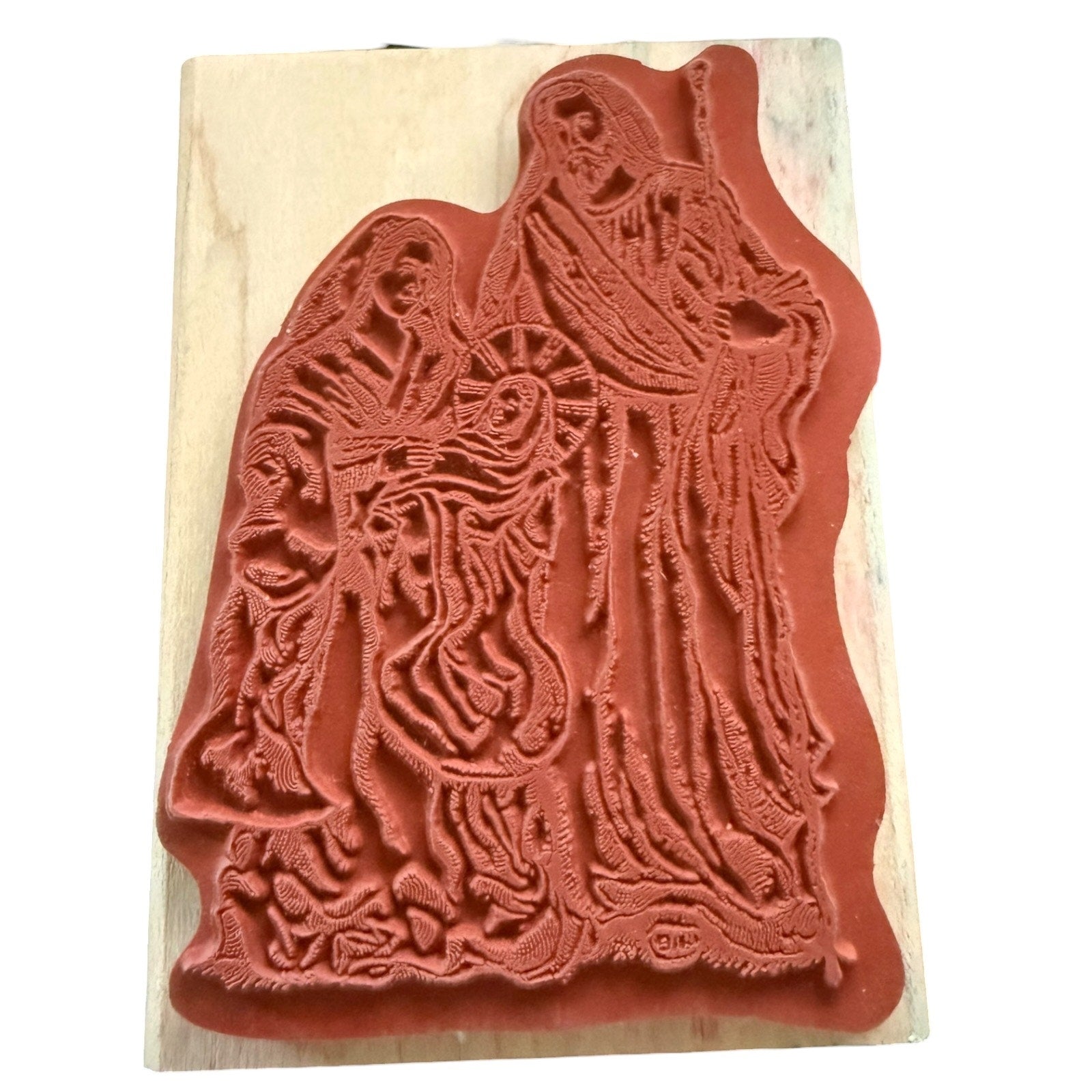 Rubber stamp with intricate design of a religious scene on a beige background