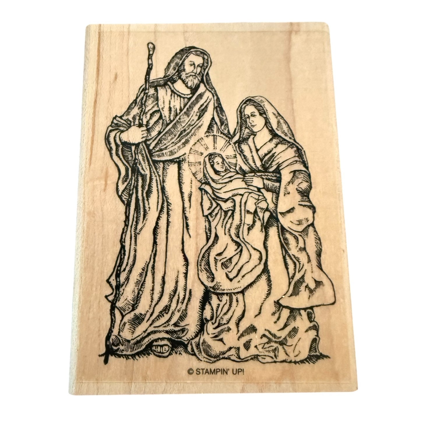 Wooden stamp with a religious scene of a man, woman, and child on a white background