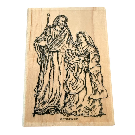 Wooden stamp with a religious scene of a man, woman, and child on a white background