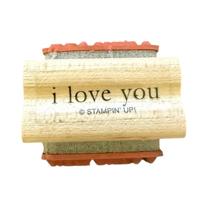 A wooden rubber stamp block with ink pad, featuring the printed text 'i love you' and '© STAMPIN' UP!' on a plain white background.