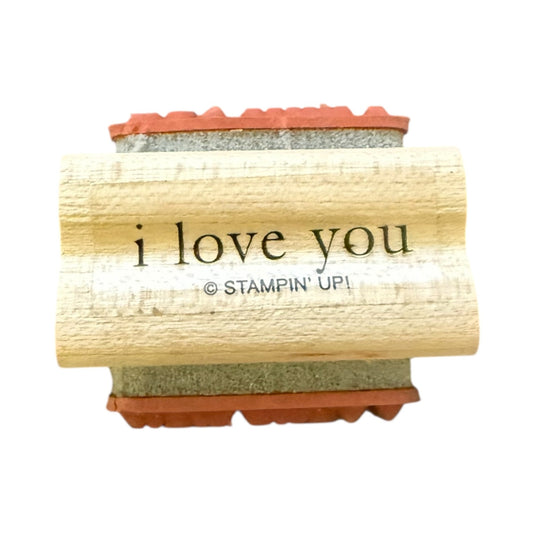 A wooden rubber stamp block with ink pad, featuring the printed text 'i love you' and '© STAMPIN' UP!' on a plain white background.