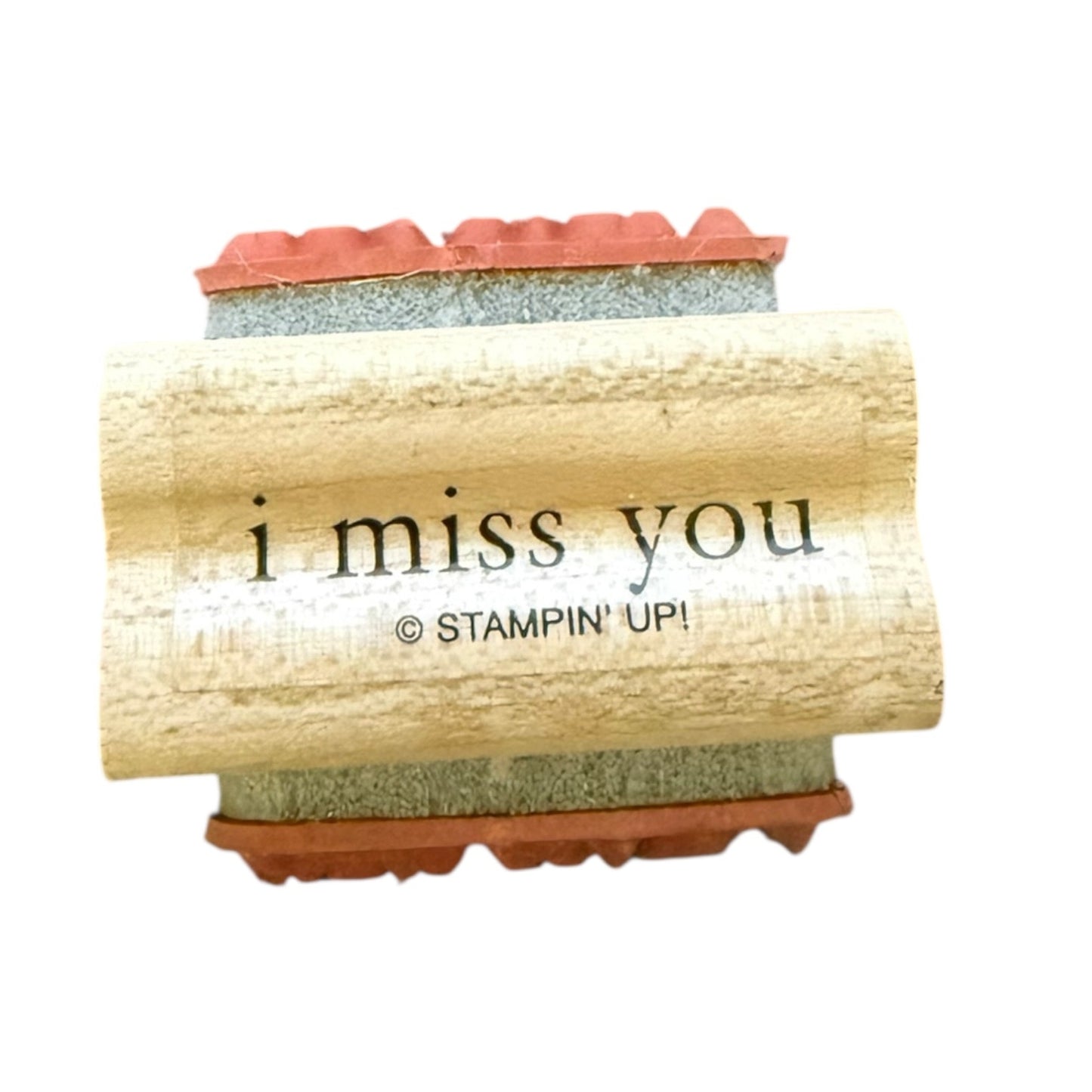 A close-up of a rubber stamp with a light wood handle printed with the words 'i miss you' and '© STAMPIN' UP!'. 