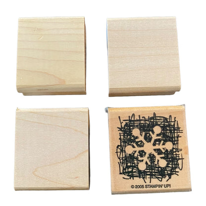Four square wooden rubber stamp blocks on a white background. 