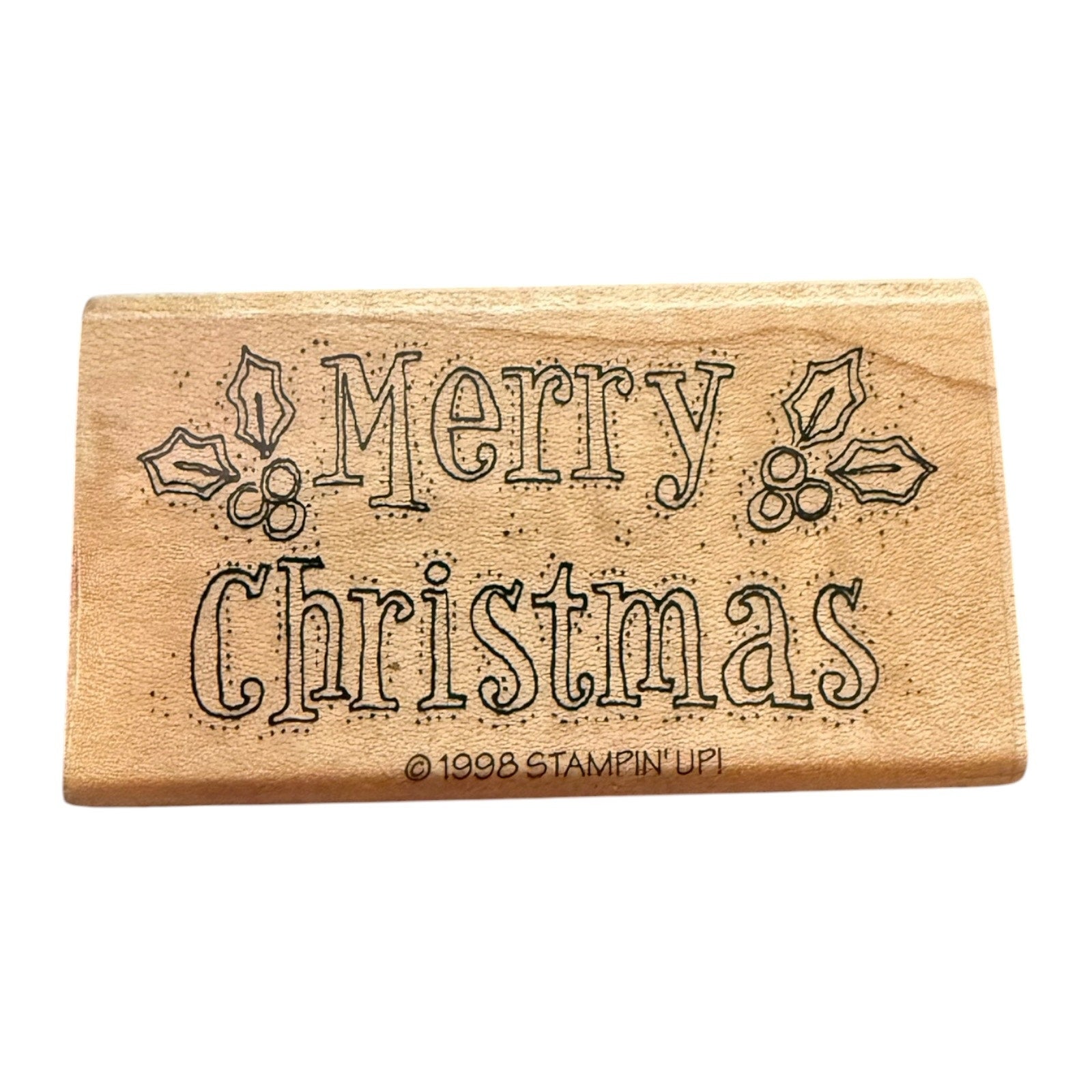 Wooden stamp with 'Merry Christmas' text on a white background