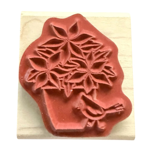 Red rubber stamp with floral design on a wooden block