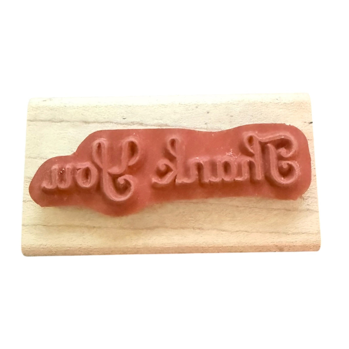 Thank You rubber stamp on a wood block with a white background. 