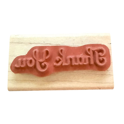 Thank You rubber stamp on a wood block with a white background. 