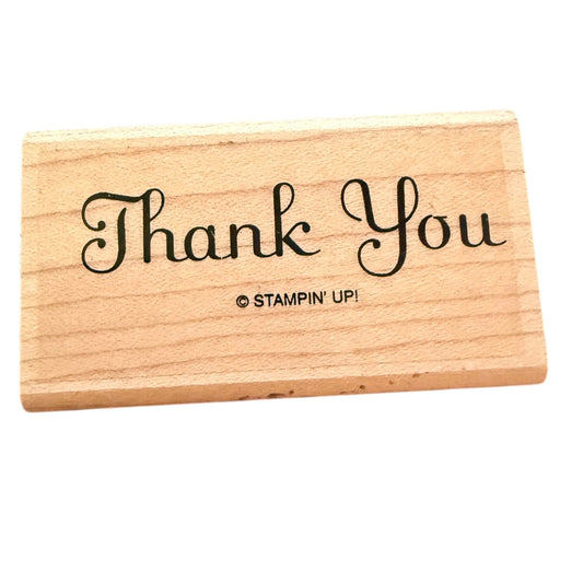 A rectangular natural wood rubber stamp block featuring the words 'Thank You' in black cursive script and the copyright mark '© STAMPIN' UP!' printed below, shown on a plain white background.