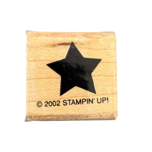 Wooden stamp with a black star and '2002 Stampin' Up!' text on a white background