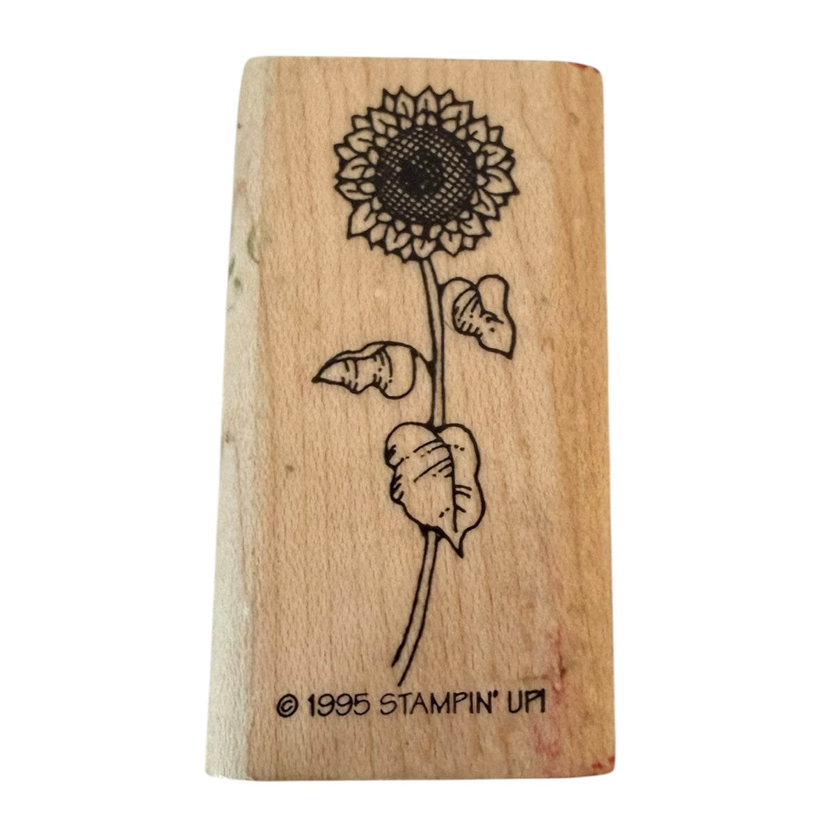 A wooden rubber stamp block featuring a sunflower design with the text '© 1995 STAMPIN' UP!' at the bottom, shown on a plain white background.