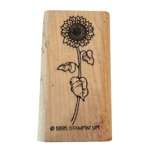 A wooden rubber stamp block featuring a sunflower design with the text '© 1995 STAMPIN' UP!' at the bottom, shown on a plain white background.
