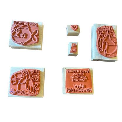 Six rubber stamp blocks with wooden bases, shown on a plain white background. 