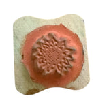 Rubber stamp with sunflower design in the center on a white background