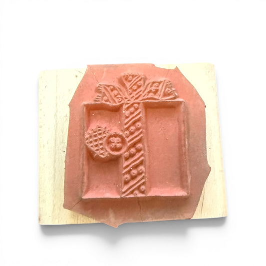Decorative rubber stamp with a present design on a wooden block against a white background