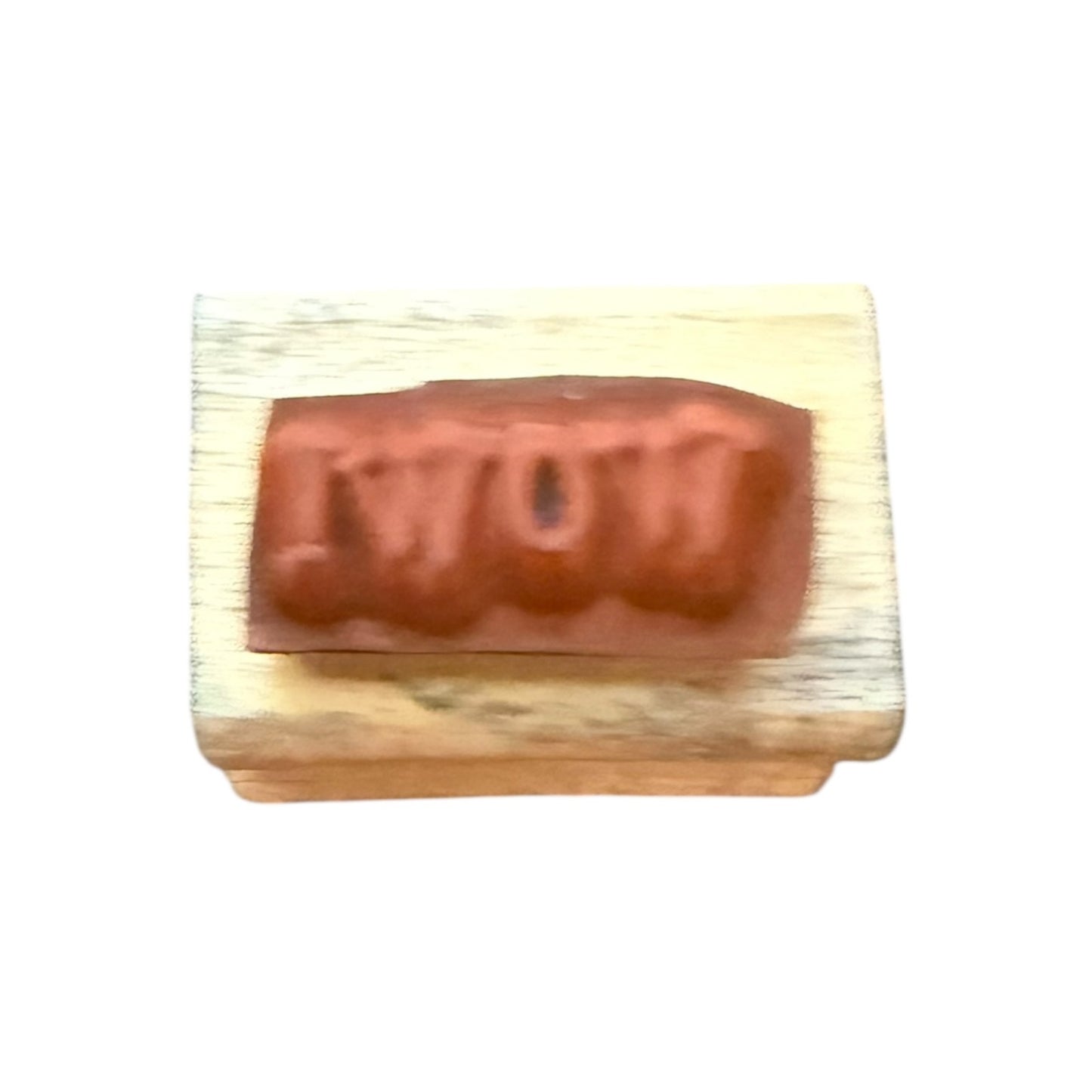 Wooden block with a red 'WOW' stamp on a white background